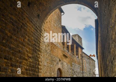 Bogengang unter dem Torre Grossa, dem höchsten Turm in San Gimignano (54 m), mit dem Äußeren des Civic Museum, Siena, Toskana, Italien Stockfoto