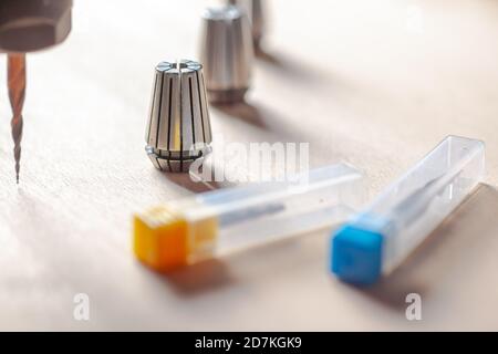 Drei Spannzangen einer cnc-Maschine, zwei Fräser in Boxen, eine Spindel mit einem Fräser einer cnc-Maschine Stockfoto