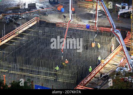 Magdeburg, Deutschland. Oktober 2020. Bauarbeiter stehen auf dem Fundament des Westabutments der neuen Pylonbrücke in der Landeshauptstadt und Pumpen Beton hinein. Derzeit werden rund 1400 Kubikmeter Beton zur Baustelle transportiert. Rund 175 Betonmischwagen oder Fahrten sind für die Anlieferung auf die Baustelle Werder erforderlich. Der Beton für das Fundament muss aus baulichen Gründen in einen Großbetrieb gestellt werden. Quelle: Peter Gercke/dpa-Zentralbild/ZB/dpa/Alamy Live News Stockfoto