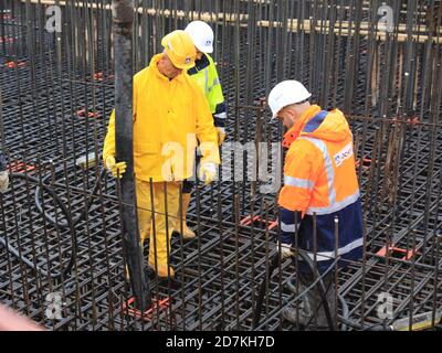 Magdeburg, Deutschland. Oktober 2020. Bauarbeiter stehen auf dem Fundament des Westabutments der neuen Pylonbrücke in der Landeshauptstadt und Pumpen Beton hinein. Derzeit werden rund 1400 Kubikmeter Beton zur Baustelle transportiert. Rund 175 Betonmischwagen oder Fahrten sind für die Anlieferung auf die Baustelle Werder erforderlich. Der Beton für das Fundament muss aus baulichen Gründen in einen Großbetrieb gestellt werden. Quelle: Peter Gercke/dpa-Zentralbild/ZB/dpa/Alamy Live News Stockfoto