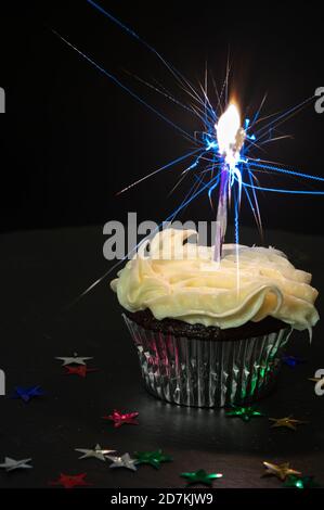 Schokoladenkuchen mit weißer Zuckerguss und Kerze Stockfoto