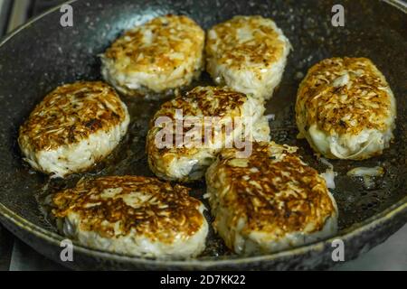 Hausgemachte Koteletts werden in einer Bratpfanne in der heimischen Küche gebraten. Hausgemachtes Essen Stockfoto