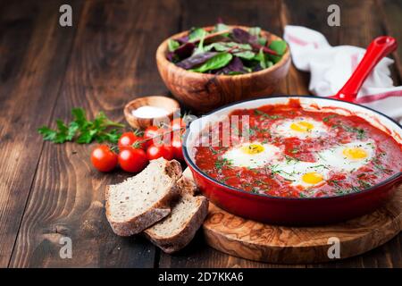 Shakshuka mit Tomaten und Eiern in einer gusseisernen Pfanne, selektiver Fokus Stockfoto