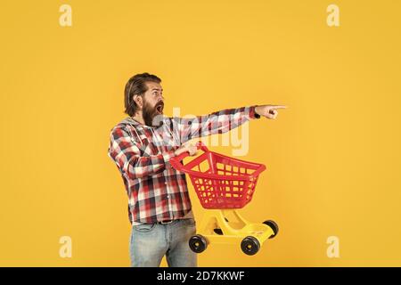 Voll einkaufen. Wochenende auf den Kauf von Produkten. Freut sich erfolgreiche Einkäufe. Brutal reifen Hipster gehen einkaufen. Seine Zeit, den Warenkorb zu füllen. Mann gehen einkaufen. Lustiger Mann mit kleinen Warenkorb. Stockfoto