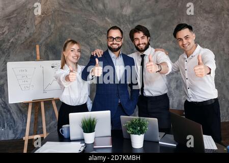 Führungskräfte mit Mitarbeitern Gruppe zeigt Daumen nach oben Blick auf die Kamera, glücklich professionelle multikulturelle Büroteam Leute empfehlen am besten Stockfoto