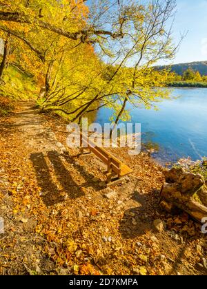 Plitvicer Seen in Kroatien Europa Holzparkbank am Morgen Spektakulärer herbstlicher Herbstfärbung Pfad Pfad ruhiger See Stockfoto