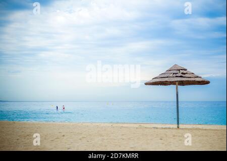 Stock Foto von einem Sonnenschirm am Strand von Villeneuve Loubet, Frankreich. Obwohl es der Sommer ist, ist der Strand verlassen wegen schlechtem Wetter . Stockfoto