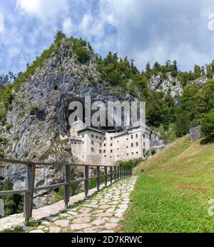 Ein Panoramabild der Burg Predjama und der umliegenden Landschaft. Stockfoto