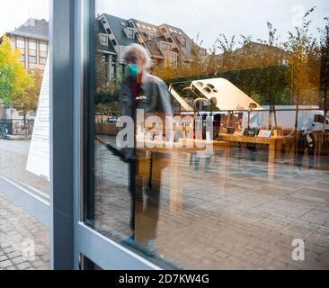 Paris, Frankreich - 23. Okt 2020: Senior man mit Maske im Apple Store mit dem neuen iPhone 12 und iPhone 12 Pro, das während des Einführungstages zu sehen ist. Die neuesten 5G-Smartphones sind weltweit erhältlich. Stockfoto