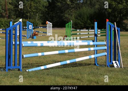 Buntes Bild von Springpfosten in einer Open-Air-Springarena. Hindernisse Pole Barrieren für springende Pferde als Hintergrund Stockfoto