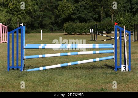 Buntes Bild von Springpfosten in einer Open-Air-Springarena. Hindernisse Pole Barrieren für springende Pferde als Hintergrund Stockfoto