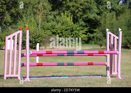 Buntes Bild von Springpfosten in einer Open-Air-Springarena. Hindernisse Pole Barrieren für springende Pferde als Hintergrund Stockfoto