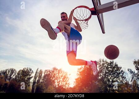 Junger Mann springen und eine fantastische Slam Dunk Streetball, Basketball zu spielen. Urbane verbindlich. Stockfoto