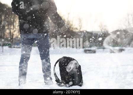 Ein Mann geht durch die Stadt auf verschneiten Wintertag. Stockfoto