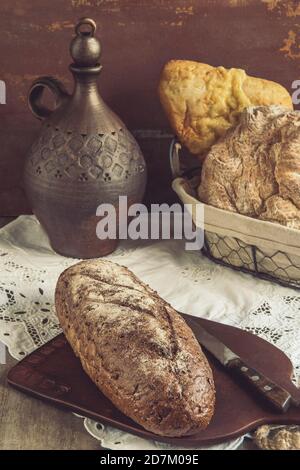 Frisch gebackenes traditionelles Brot auf einem Schneidbrett. Frisches Roggenvollkornbrot mit Sauerteig und Kleie Stockfoto
