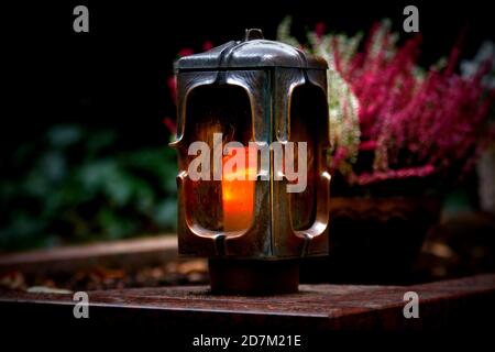 Grablaterne aus Metall mit brennender Kerze Stockfoto