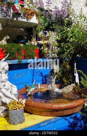 Ein kleiner solarbetriebener Wasserbrunnen ist Teil einer Besonderheit In einem Märchengarten Stockfoto