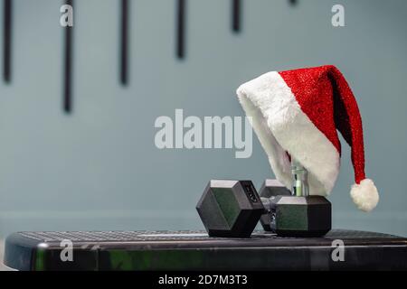 Weihnachtsmütze im Fitnessstudio. Konzept des Sports zu Weihnachten und Neujahr. Fitness, gesunde und aktive Lebensstil Konzept. Stockfoto