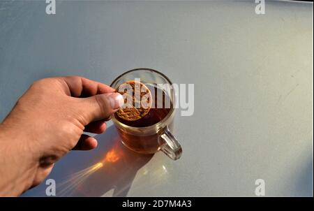 Keks und türkischer Tee mit bunten Schatten. Kekse in frisch gebrühten türkischen Tee eintauchen:köstlich. Stockfoto