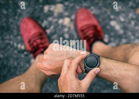 Smartwatch Wearable Tech-Gerät passen Sportler Mann Überprüfung intelligente Sportuhr-Technologie auf Fitness-Lauf joggen draußen. First Person Blick von oben zeigt Stockfoto