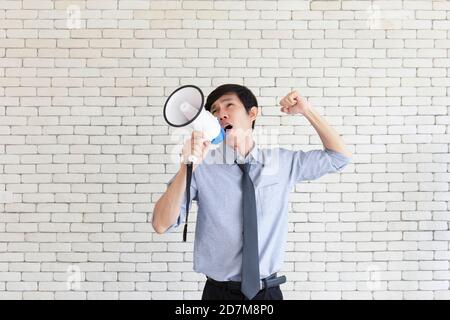 Ein junger asiatischer Mann schnappte sich ein Megaphon und schrie wütend. Stockfoto