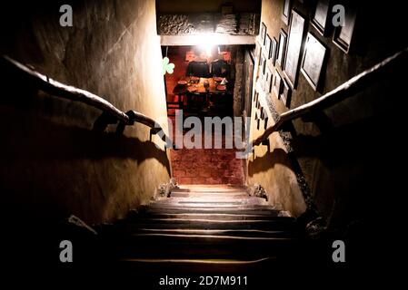 Dramatische Sicht auf die unheimlich Treppen von oben in die Dunkelheit des Inneren des alten Pubs Stockfoto