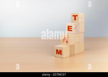 Das Wort Team auf Holzblöcke geschrieben, dass eine Person Builds Stockfoto