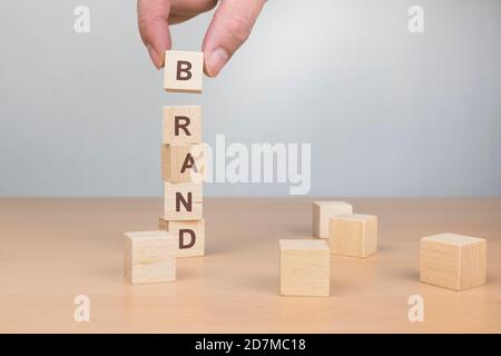 Holzklötze mit dem Wort MARKE von Hand arrangieren. Konzept zur Markenbildung. Stockfoto