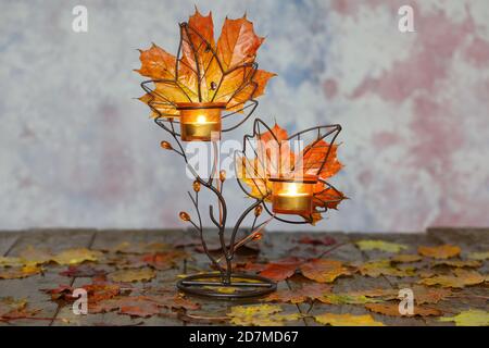 Herbstkomposition mit gelben Blättern und Kerzen Stockfoto