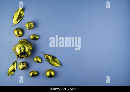 Kürbisse, Nüsse und Blätter in Gold auf violettem Hintergrund gemalt. Flaches Layout mit Platz für Text. Hochwertige Fotos Stockfoto