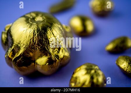 Kürbisse und Nüsse in Gold auf violettem Hintergrund gemalt. Flaches Layout mit Platz für Text. Hochwertige Fotos Stockfoto