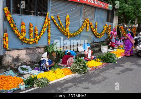 Frauen verkaufen Ringelblumen und Girlanden auf der Straße am Vorabend des Festivals von Dasara Ort: Maharashtra, Indien Datum: Oktober 24 2020 Stockfoto