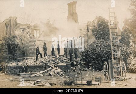 Vikar des Heiligen Smwithun, östlich Grinstead, durch Feuer am 27. Februar 1908 zerstört. 1848 erbaut, wohnte Reverend Douglas Blakiston (Vikar seit 1871) zu dieser Zeit bei seiner Familie. Nach dem Brand wurde er schwer erschüttert und zog sich zurück. Feuerwehr und Polizei mit Hydranten und Leiter. Ort: East Grinstead, West Sussex, England. Foto aus DER SAMMLUNG JOHN STEVEN DUTTON. Stockfoto