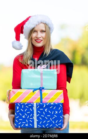 Junge blondie Frau in Weihnachtsmütze Weihnachten mit gekleidet Geschenk Stockfoto