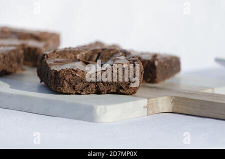 Nahaufnahme von köstlichen Fudge Brownies aufeinander gestapelt Ein geschnittenes Brett Stockfoto