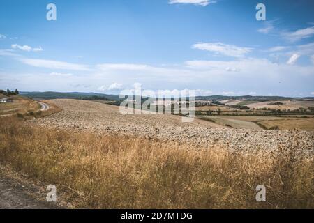 Vespa Tour auf Schotterstraße in Toscane in Italien durch Die frisch geschnittenen Getreidefelder Stockfoto