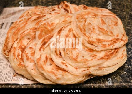 Vorbereitung von Aloo Paratha oder roti parantha chapati Punjab, Nordindien. Weibliche Hand Rollen Vollkornteig Kartoffelpüree. Kerala parotta porotta Stockfoto