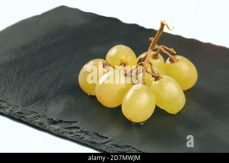 Zweig der weißen Trauben auf schwarzem Teller Hintergrund. Stockfoto