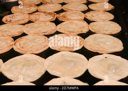 Vorbereitung von Aloo Paratha oder roti parantha chapati Punjab, Nordindien. Weibliche Hand Rollen Vollkornteig Kartoffelpüree. Kerala parotta porotta Stockfoto