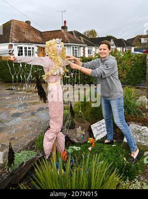 Worthing UK 24. Oktober 2020 - Lorraine Piddock bringt den letzten Schliff zu einer der hundert Vogelscheuchen, die rund um das Dorf Ferring in der Nähe von Worthing an diesem Wochenende erschienen sind, wie ihre Scarecrow Festival findet diese Woche : Credit Simon Dack / Alamy Live News Stockfoto