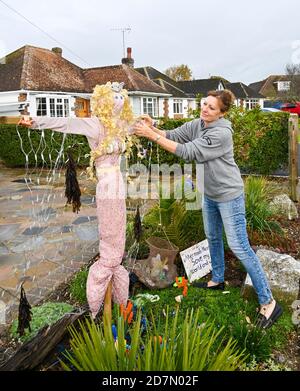 Worthing UK 24. Oktober 2020 - Lorraine Piddock bringt den letzten Schliff zu einer der hundert Vogelscheuchen, die rund um das Dorf Ferring in der Nähe von Worthing an diesem Wochenende erschienen sind, wie ihre Scarecrow Festival findet diese Woche : Credit Simon Dack / Alamy Live News Stockfoto