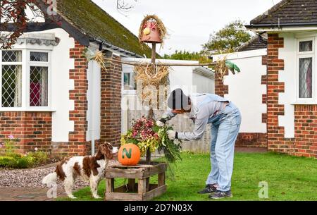 Worthing UK 24. Oktober 2020 - Sophie Worgon bringt den letzten Schliff eine der Vogelscheuchen, die dieses Wochenende im Dorf Ferring bei Worthing erschienen sind, während ihr Vogelscheuchen-Festival diese Woche stattfindet : Credit Simon Dack / Alamy Live News Stockfoto