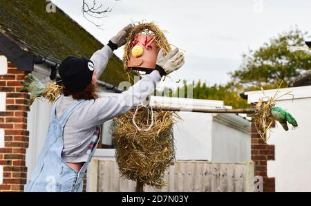 Worthing UK 24. Oktober 2020 - Sophie Worgon bringt den letzten Schliff eine der Vogelscheuchen, die dieses Wochenende im Dorf Ferring bei Worthing erschienen sind, während ihr Vogelscheuchen-Festival diese Woche stattfindet : Credit Simon Dack / Alamy Live News Stockfoto