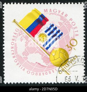 UNGARN – UM 1962: Stempel gedruckt von Ungarn, zeigt Flaggen von Kolumbien und Uruguay und Soccerball, um 1962 Stockfoto