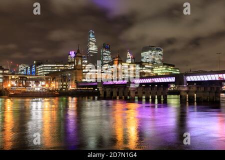 Blick über die Themse zu den beleuchteten City of London Wolkenkratzern bei Nacht, London, Großbritannien Stockfoto