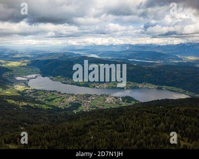 Luftdrohnenblick auf den Ossiacher See in Kärnten, Österreich an einem Sommertag mit toller Wolkenlandschaft und dem Wörthersee im Hintergrund Stockfoto