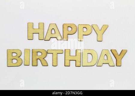 Happy Birthday geschrieben mit Holzbuchstaben auf weißer Oberfläche Stockfoto