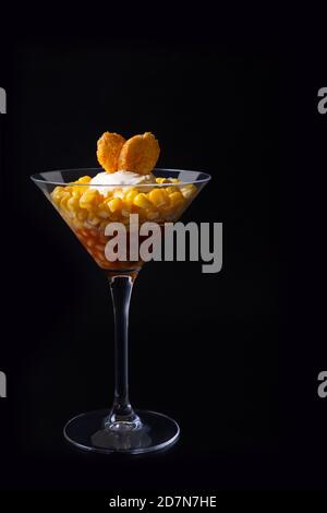 Salat aus Bohnen, Mais und Croutons in einem martini-Glas. Schwarzer Hintergrund, Low-Key, Nahaufnahme. Konzept. Stockfoto