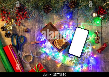 Weihnachtshintergrund mit Tannenzweigen, roten Beeren, Zapfen und Weihnachtslichtern auf dunklem abstrakten Hintergrund. Weihnachtsbeleuchtung und Dekorationen, Konzept prepara Stockfoto
