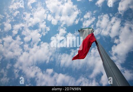 Mexikanische Flagge flattert über einem Wolkenhimmel an einem sonnigen Tag. Stockfoto